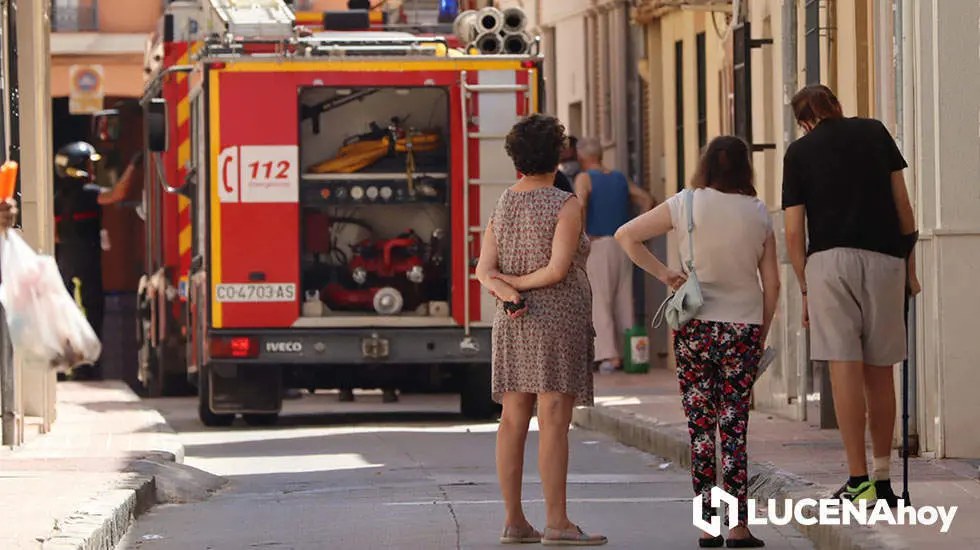 Varios vecinos observan el edificio en el que se ha producido el incendio en Lucena