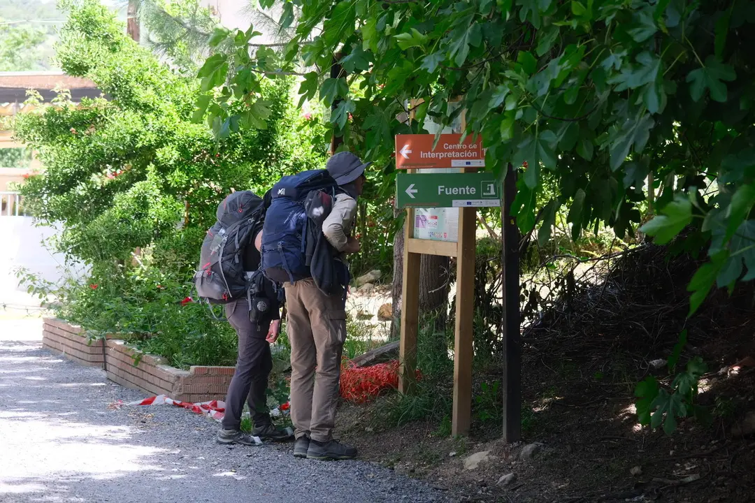 Dos turistas observan las indicaciones del sendero