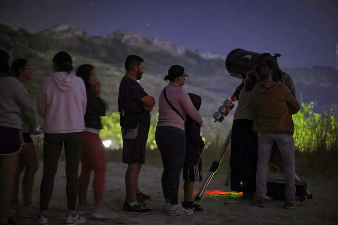 Varias personas participan en una actividad de astroturismo. Imagen de archivo.