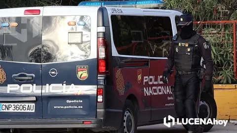 Un agente se dirige a uno de los veh&iacute;culos situados ante uno de los edificios registrados durante la operaci&oacute;n junto a la N331 