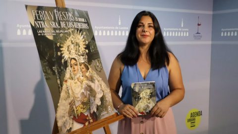 La delegada de alcald&iacute;a en Las Navas, Carolina Cierto, junto al cartel anunciador de las fiestas, obra de Jos&eacute; Sillero G&oacute;mez.