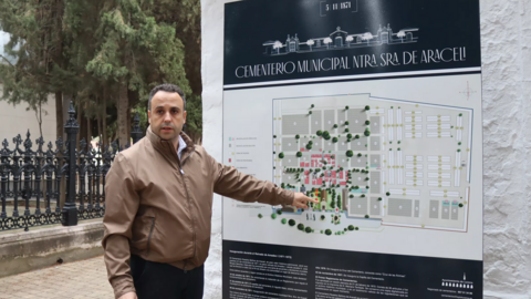 Javier Pineda junto al panel informativo instalado a la entrada del cementerio