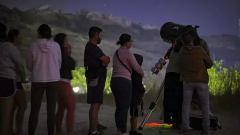 Varias personas participan en una actividad de astroturismo. Imagen de archivo.