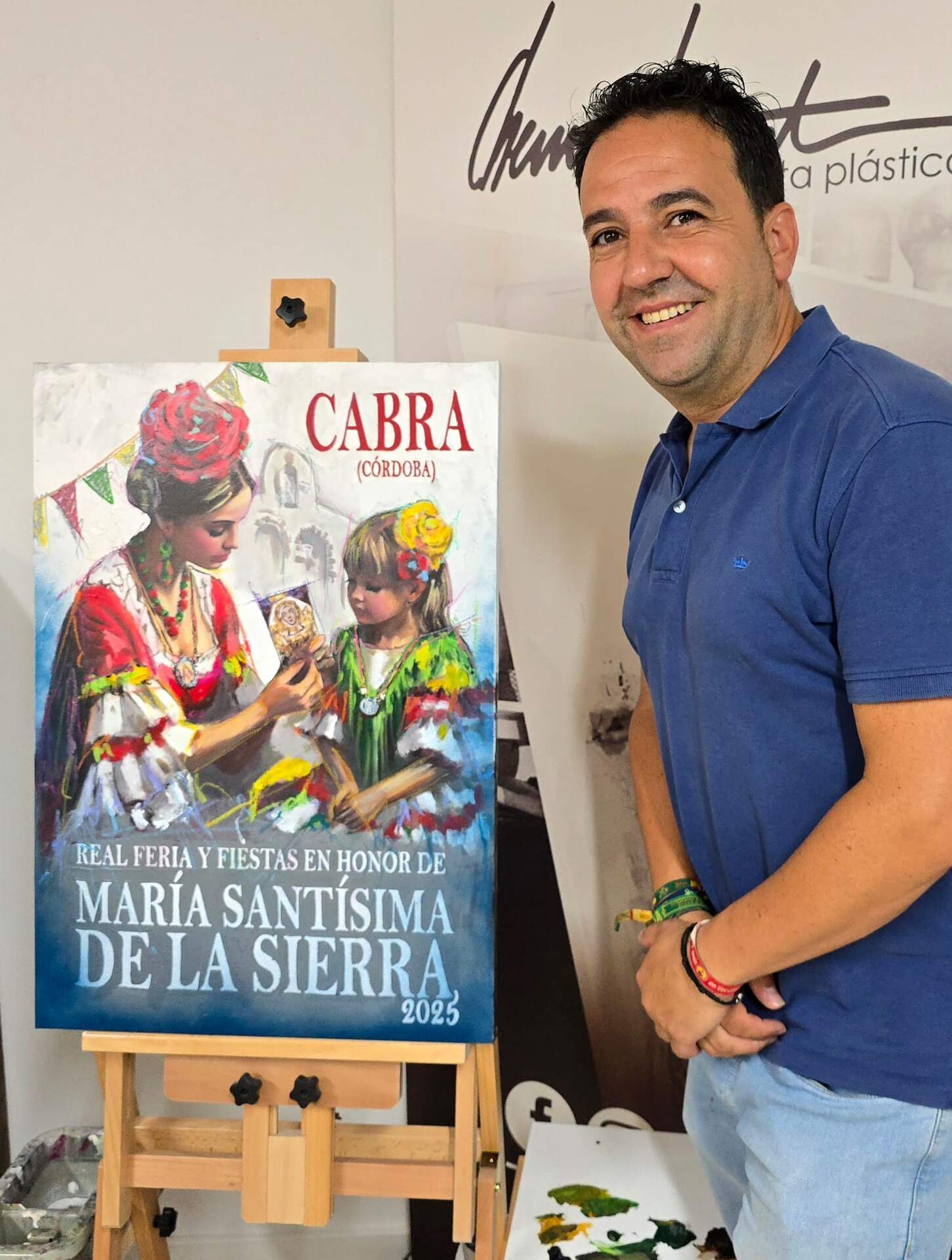 Chema Riquelme, junto al cartel de la Real Feria y Fiestas en honor a María Santísima de la Sierra.
